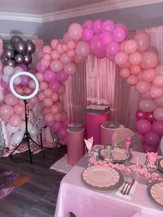 a table set up for a party with pink and silver decorations