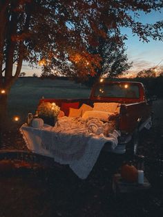 an old pick up truck is parked under a tree with some lights on the bed