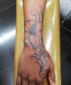 a person's hand with a flower tattoo on it