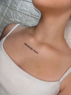 a woman with a tattoo on her chest that reads, born to saturn written in cursive font