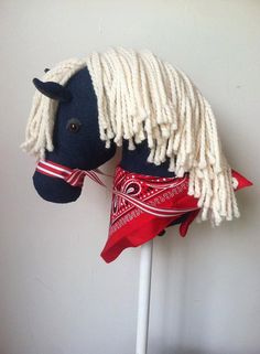 a stuffed horse with white hair and red bandannas on it's head