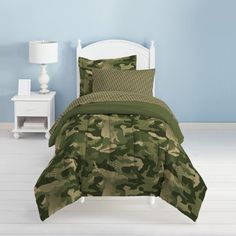 a bed with green camouflage comforter and pillows