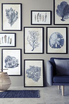 a living room with pictures on the wall and a blue chair in front of it