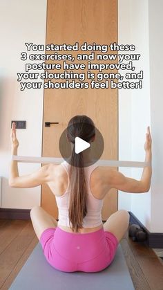 a woman sitting on a yoga mat with her hands in the air while doing exercises