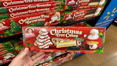 christmas tree brownies are being held up by someone's hand in a store