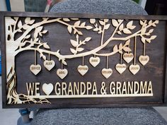 a wooden sign that says we love grandpa and grandma with hearts hanging from the tree