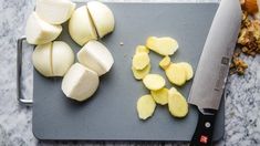 chopped up onions on a cutting board next to a knife and some diced potatoes