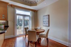 a dining room table with four chairs and an open glass door leading to a patio