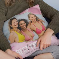 a woman sitting in a chair holding a pillow with two women on it and the caption be strong