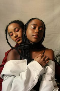 two women with braids on their heads sitting next to each other