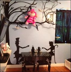 a dining room table and chairs in front of a wall with the silhouettes of children on it