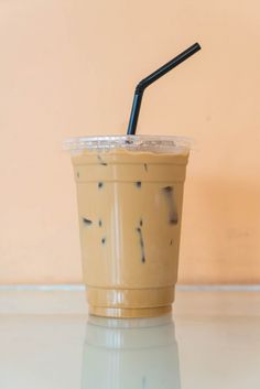 a cup with a straw in it sitting on a table