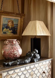 a lamp sitting on top of a table next to a vase and dog figurine