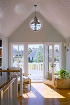 the sun shines through the windows in this home's living room, which is decorated with white trim and wood flooring