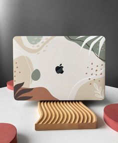 an apple laptop sitting on top of a wooden stand