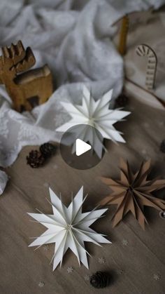 paper snowflakes and pine cones on a table