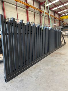 a large metal fence in a warehouse with tables and chairs around it, along with other equipment