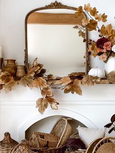 a mirror and some baskets in front of a fire place with flowers on the mantle