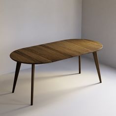 a wooden table sitting on top of a white floor next to a wall in an empty room