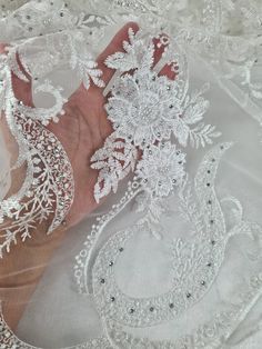 A beautiful white embroidered tulle, it truly is stunning. It has white thread embroidered flowers, and embellished with white coloured pearls and crystal diamontes. It has a double edged border.  The tulle is soft and has a good drape to it, making it ideal for any item of clothing, especially dresses, bridal or bridesmaid.  Width: 52 inch wide Sold of the roll, if you buy more than one meter, fabric will be in a continuous length. Although we have taken great care to portray the true colour of Wedding Lace, Embroidered Tulle, Lace Weddings, Tulle Fabric, Pearl Color, Embroidered Flowers, Bridal Wear, Bridesmaid Dress, True Colors