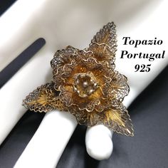 *Description: This is a beautiful Topazio Portugal sterling silver brooch dipped in gold vermeil from the 1930s to early 1940s. The floral filigree work is stamped TOPAZIO PORTUGAL on the back with 925. I tested the top surface and it tested at 10K gold vermeil over the sterling silver. This would be a great addition to your vintage jewelry collection or make a great vintage gift! *Approximate Measurements: Length - 2 Inches, Width - 1 3/4 Inches, Weight - .5 Ounce *Condition: Great vintage cond Antique Yellow Gold Filigree Brooches, Victorian Gold Brooches With Intricate Design, Gold Victorian Brooches With Intricate Design, Victorian Gold Brooch With Intricate Design, Gold Victorian Brooch With Intricate Design, Flower Shaped Wedding Brooches Hallmarked, Wedding Flower Brooches Hallmarked, Wedding Flower Brooch Hallmarked, Flower Shaped Wedding Brooches