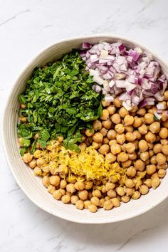 a bowl filled with chickpeas, onions, and cilantro on top of a white counter