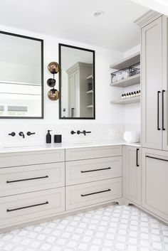 a white bathroom with two sinks and mirrors