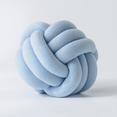 a blue ball that has been made out of knitted yarn and is sitting on a white surface