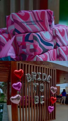 pink boxes with hearts are on display in the store's window and behind them is a sign that says bride to be