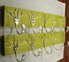 several metal hooks mounted to a wall with deer heads on them