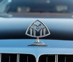 an emblem on the front of a black maserato car is seen in this image