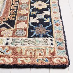 a multicolored area rug on the floor with white wood floors and light colored carpeting