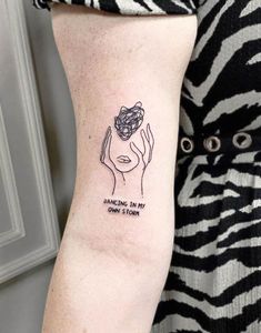 a woman's arm with a tattoo on it that says dancing in my own storm