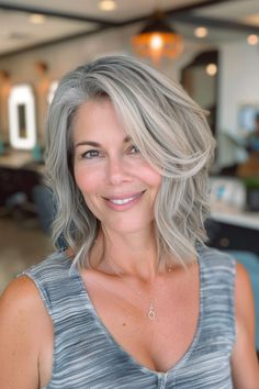 Smiling woman with shoulder-length gray hair in a modern salon. Blonde Hair With Gray Roots, High And Low Lights For Gray Hair, Blonde Highlights On Grey Hair, Blonde To Gray Hair Transition, Gray Hair With Blonde Highlights, Blonde Grey Blending, Silver Blonde Highlights, Blonde Hair With Silver Highlights, Blonde Hair With Grey Highlights