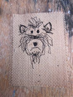 a dog's face is drawn on a piece of burlock