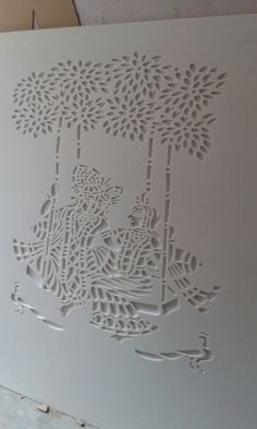 an intricate cutout on the side of a white paper with trees and animals in it