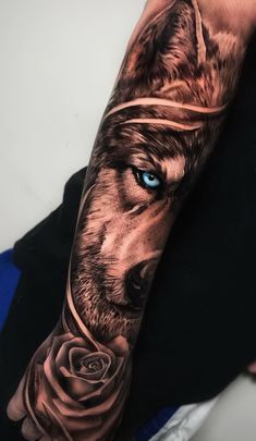 a man's arm with a wolf and rose tattoo on it