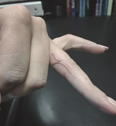 a person's hand with a small tattoo on it