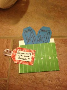 a pair of shoes sitting on top of a football field next to a paper cutout