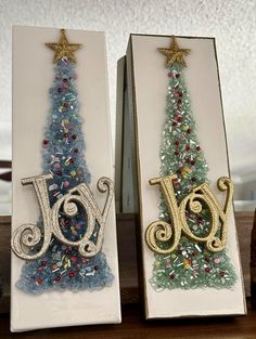 two christmas trees made out of paper and bead