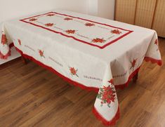 a white table with red trim and poinsettis on the border is shown