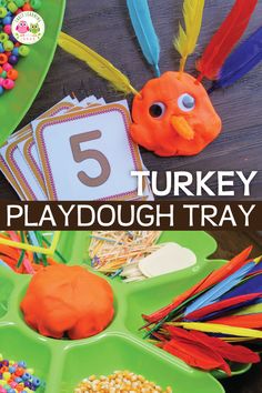 the turkey playdough tray is filled with colorful feathers and beads