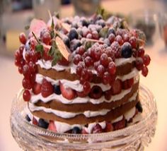 a layered cake with berries and cream on top