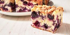 a piece of blueberry crumb cake sitting on top of a table next to a plate