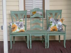 two green chairs sitting next to each other on a porch