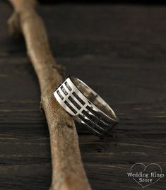 a silver ring sitting on top of a piece of wood