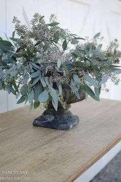 a vase filled with flowers sitting on top of a wooden table