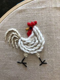 a close up of a rooster on a piece of fabric