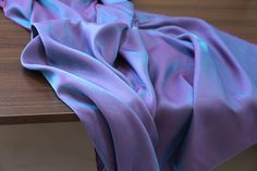 a purple blanket sitting on top of a wooden table