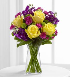 a vase filled with yellow and purple flowers